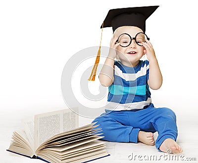 Baby Read Book, Smart Kid Boy in Glasses and Mortarboard Hat Stock Photo