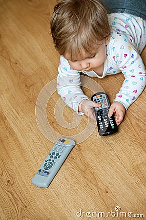 Baby with remote controls Stock Photo