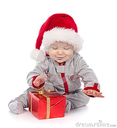 Baby in Santa hat playing with Christmas gift box Stock Photo