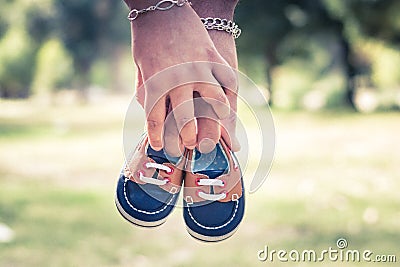 Baby shoes and potato hands Stock Photo