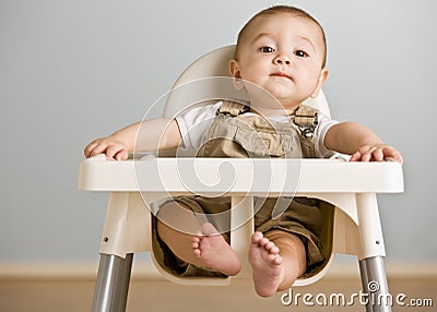 Baby sitting in highchair Stock Photo