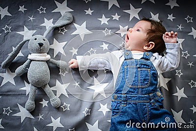 The baby is sleeping with a toy. a small child sleeps by the window, dreaming of a starry sky before going to bed. sleep concept. Stock Photo