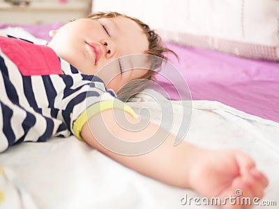 Baby sleeps in parents bed. arms outstretched baby`s restful sleep. close-up. child 0-1 years old. adorable lovely baby sleeps Stock Photo