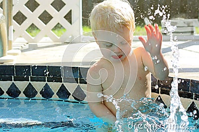 Baby Splashing Water in Backyard Swimming Pool Stock Photo