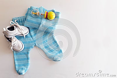 Baby stuff is on a white background. Things for little boy, rattle and shoes. Newborn baby necessities. Stock Photo