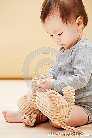 Baby, stuffed animal and playing in home for comfort care, childhood development or game entertainment. Kid, toy teddy Stock Photo