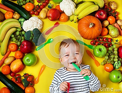 Baby surrounded with fruits and vegetables Stock Photo