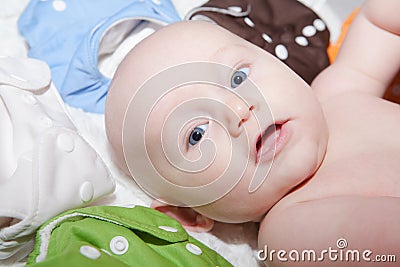 Baby Surrounded by a Rainbow of Cloth Diapers Stock Photo
