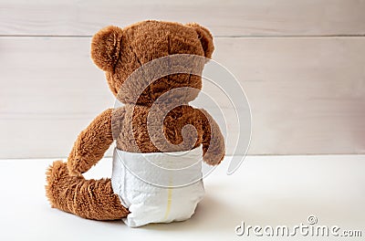 Baby teddy wearing diaper sitting on white color floor Stock Photo