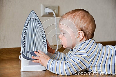 Baby touching hot iron Stock Photo