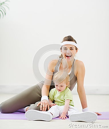 Baby trying to wear mothers sneakers Stock Photo