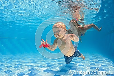 Baby underwater swimming lesson with instructor in the pool Stock Photo