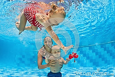 Baby underwater swimming lesson with instructor in the pool Stock Photo