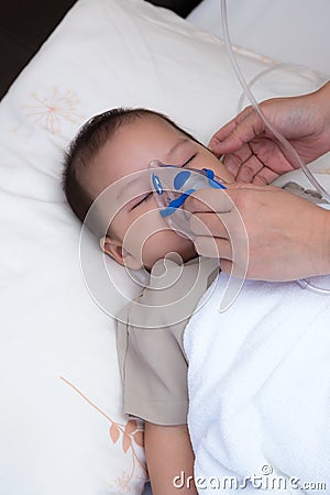 Baby using spacer for respiratory infection Stock Photo