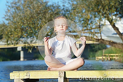 Baby yoga Lotus pose.. a child practicing yoga outdoors Stock Photo