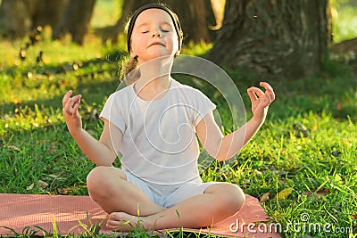 Baby yoga Lotus pose.. a child practicing yoga outdoors Stock Photo