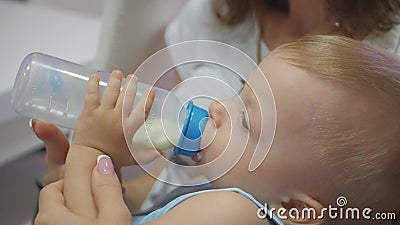 Babyjongen, in slaap met fles De mooie consumptiemelk van de babyjongen van fles, sluit omhoog stock videobeelden Babyjongen, in slaap met fles De mooie consumptiemelk van de babyjongen van fles, sluit omhoog stock videobeelden
