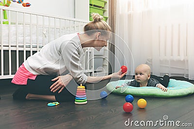 Babysitting - nanny playing with little baby on the floor Stock Photo