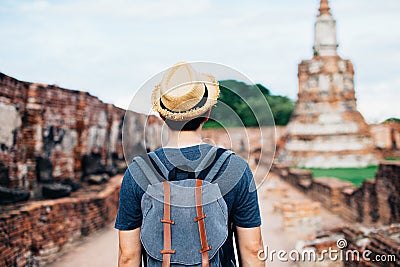 Back of Asian male solo traveller walks inside historical buddhist ruins heritage Stock Photo