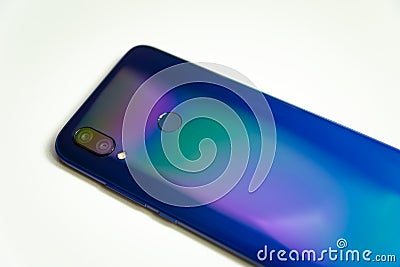 The back of a blue smartphone with two cameras and a flash on a white background Stock Photo