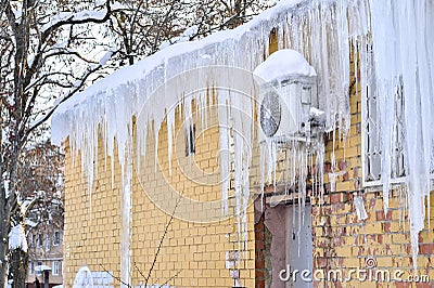 The back of the building is air-conditioned cafe on the wall covered with a thick layer of icicles Stock Photo