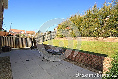 Back garden with paved area and sloping lawn Stock Photo