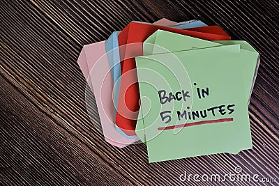 Back in 5 Minutes write on sticky notes isolated on Wooden Table Stock Photo
