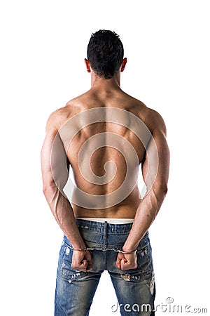 Back of muscular shirtless young man with handcuffs Stock Photo