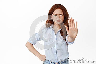 Back off I said no. Angry redhead woman extend one hand to block, say stop, prohibit something with displeased frowning Stock Photo