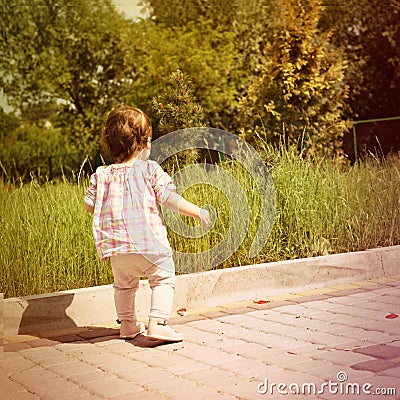 Back shot of little baby girl. First steps. Stock Photo