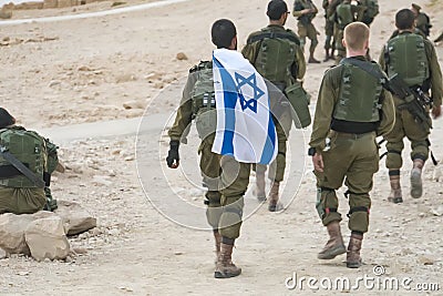 Back shot of several soldiers of israel army walking with israel national flag. Military man bearing israel flag on his shoulder Editorial Stock Photo