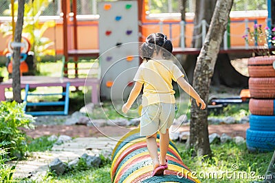 Back side. Asian girl play on school or kindergarten yard or playground. Healthy summer activity for children. Little asian girl Stock Photo