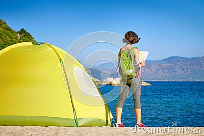 Back side of backpacker girl searching right direction on map. Stock Photo