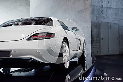 Back, side view of white fast sport car with right diode backlight, blue mirror with turn signal, trunk, light alloy Stock Photo