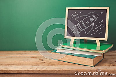 Back to school background with books, chalkboard and rocket sketch Stock Photo