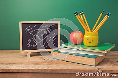 Back to school background with books, pencils in emoji jar, apple, chalkboard and rocket sketch Stock Photo