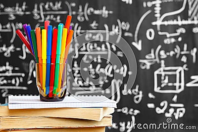 Back to school background with colorful pencils on the books and notebook and the title `Back to school` written by white chalk Stock Photo