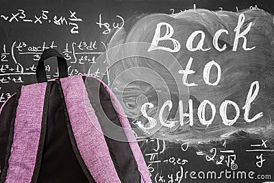 Back to school background with purple school bag and the title `Back to school` and math formulas written by white chalk Stock Photo