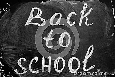 Back to school background with title `Back to school` written by white chalk on the black chalkboard. Stock Photo