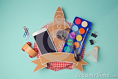 Back to school badge design with smartphone and cardboard rocket. Creative design hero header image. View from above. Stock Photo