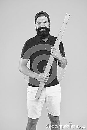 Back to school. Bearded man with big measuring instrument. Measuring his height with ruler. gauge and measuring Stock Photo