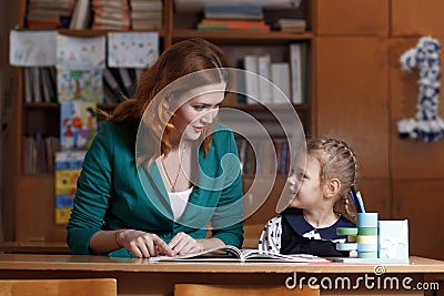 Back to school. Child is learning to write. Adult woman teaches child the alphabet. Stock Photo