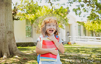 Back to school. Child with rucksacks standing in the park near school. Pupils with books and backpacks outdoors. Stock Photo