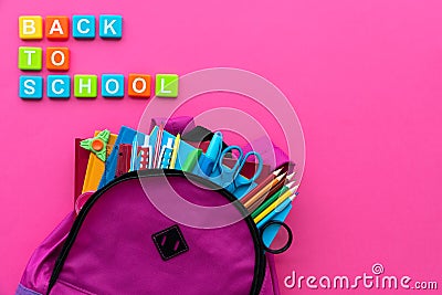 Back to school concept. Backpack with school supplies and alphabets and numbers blocks on pink background. Top view. Copy space Stock Photo