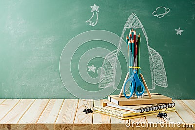 Back to school concept with rocket sketch, pencils and notebook on wooden table background Stock Photo