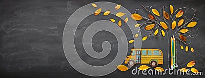 Back to school concept. Top view banner school bus and pencils next to tree sketch with autumn dry leaves over classroom blackboar Stock Photo