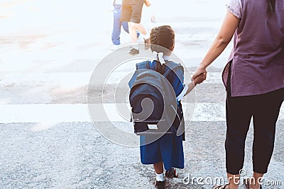 Cute asian pupil girl with backpack holding her mother Stock Photo