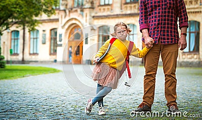 Back to school. Funny portrait child. Pupil girl of primary school go hand in hand with dad. Teacher and cute schoolgirl Stock Photo