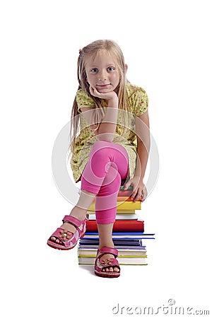 Back to school. Girl sitting on a stack of books Stock Photo