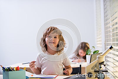 Back to school. Happy cute child is sitting at a desk indoors. Cild is learning in class. Stock Photo